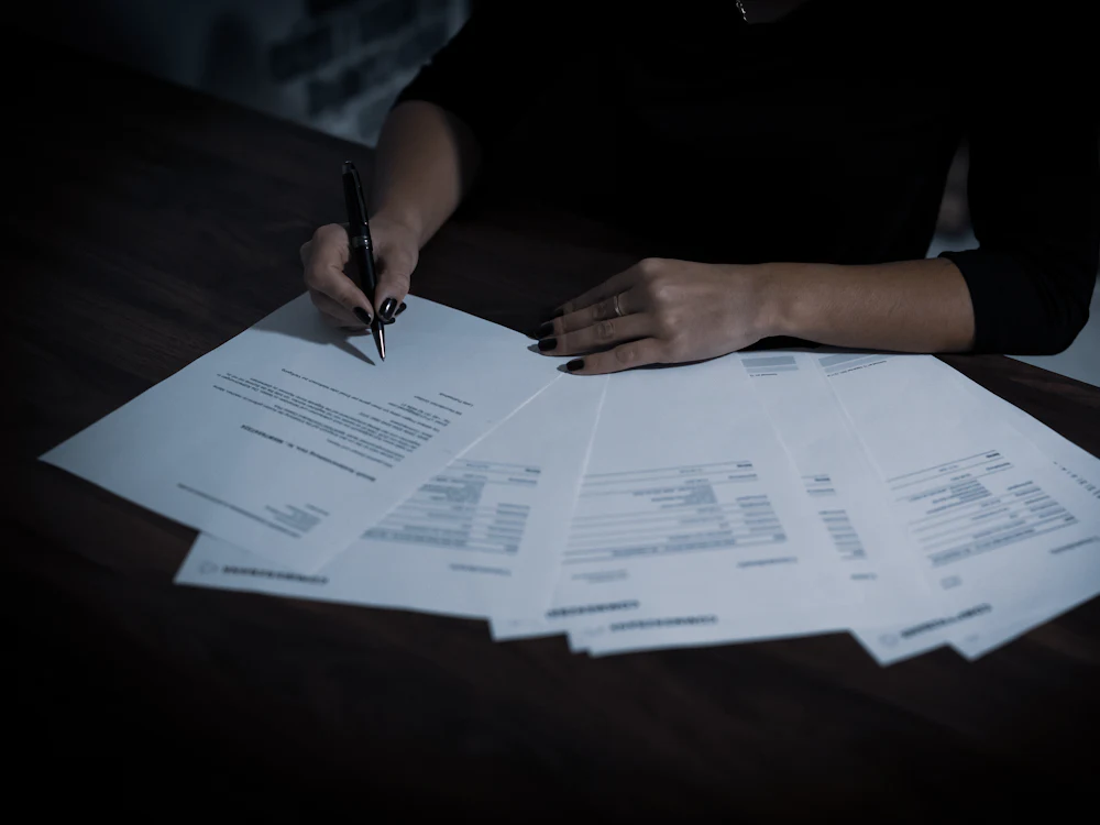 Mujer organizando papeles importantes en la mesa