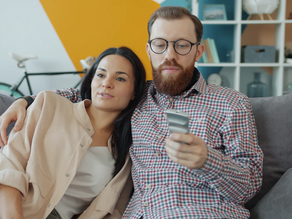 Pareja en el sofá de casa revisando una compra